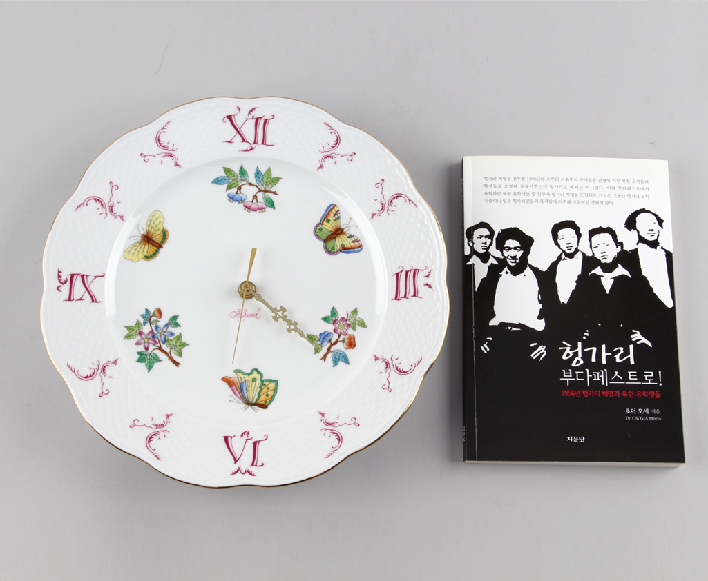 도자기 벽시계와 ‘헝가리 부다페스트로’라는 제목의 책 Porcelain wall clock and book entitled ‘To Budapest, Hugary’